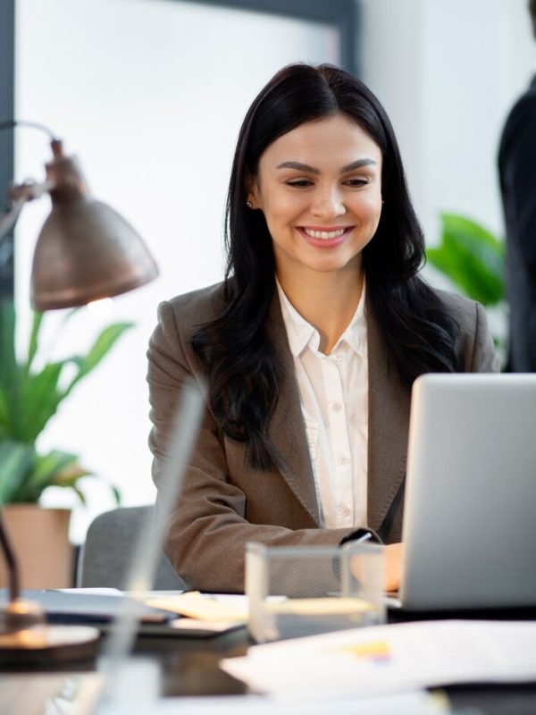 close-up-smiley-woman-working-laptop_23-2149300651